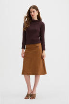Claude Knit and Kingma A-Line Skirt. A woman modeling a dark brown draped knit sweater and a rust linen A-line skirt against a plain white studio background.